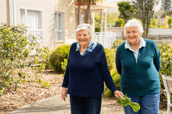 two old people walking in the lady allum retirement vilage